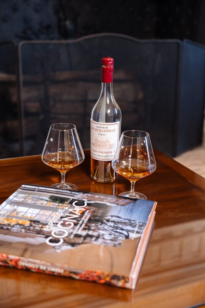 A bottle of cognac and two glasses on a table