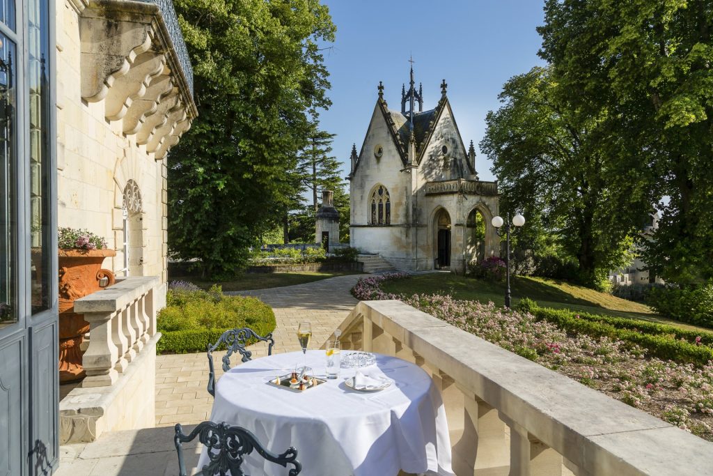 A table laid for breakfast on the terrace with the chapel beyond