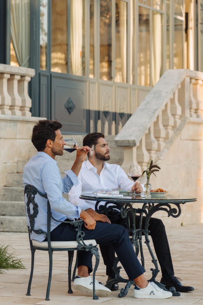 Two guests with glasses of wine on the terrace steps