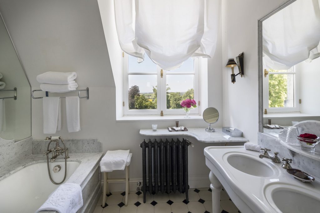 A bathroom with a bathtub and two washbasins