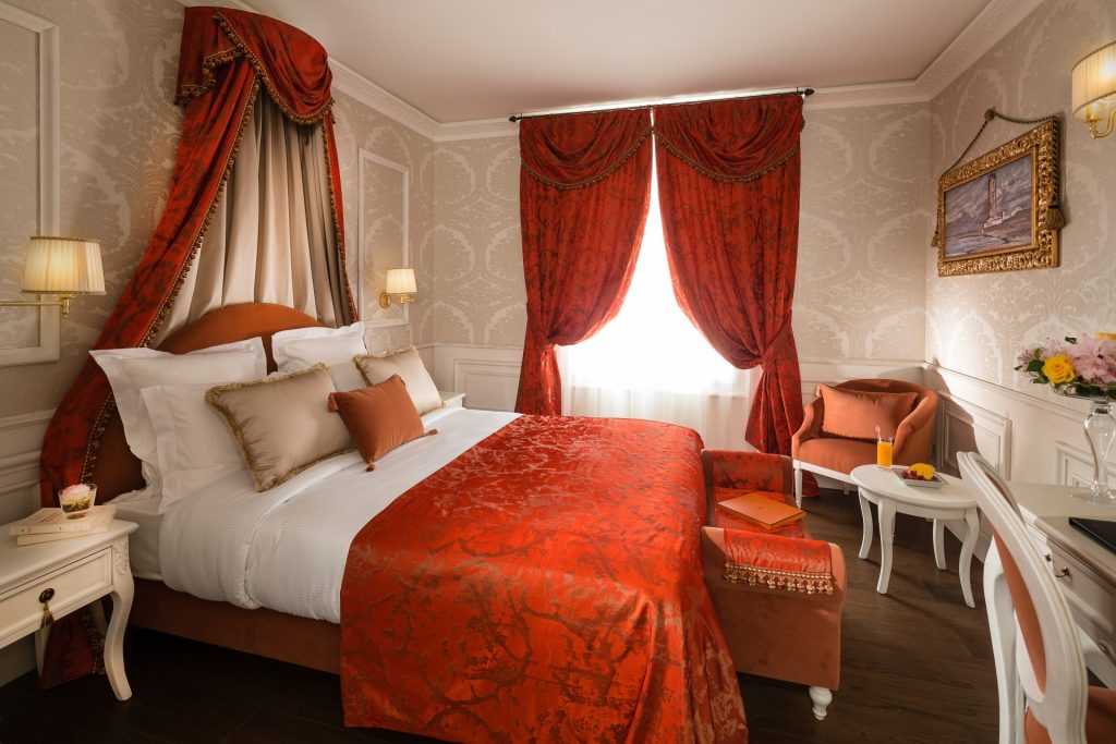 Une chambre classique avec un rideau rouge et un couvre-lits