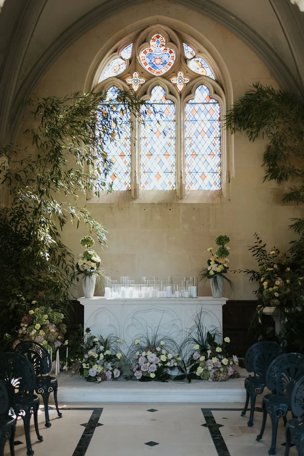 The château chapel with its stained-glass window, a flower-dressed altar and garden chairs