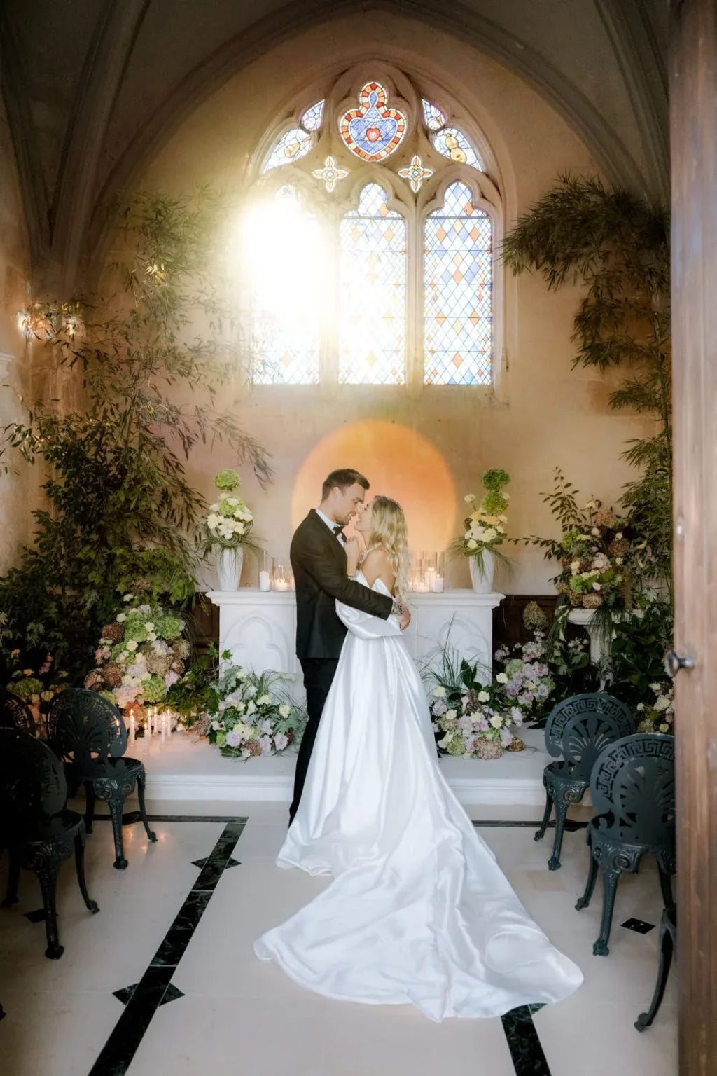 A bride and groom at the flower-dressed altar of the château chapel