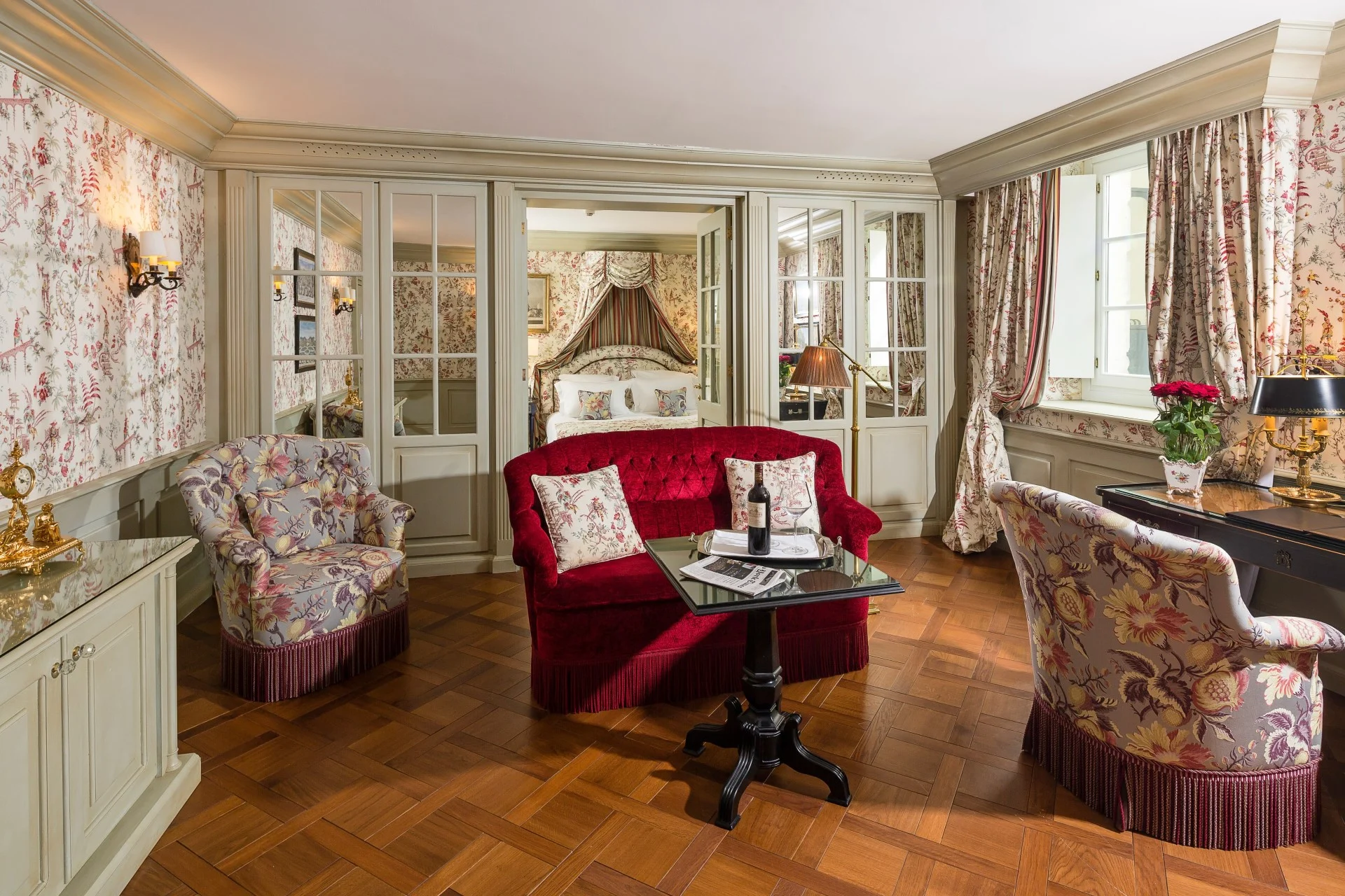 Une salle d'attente Galerie Suite avec un canapé et des fauteuils en velours rouge