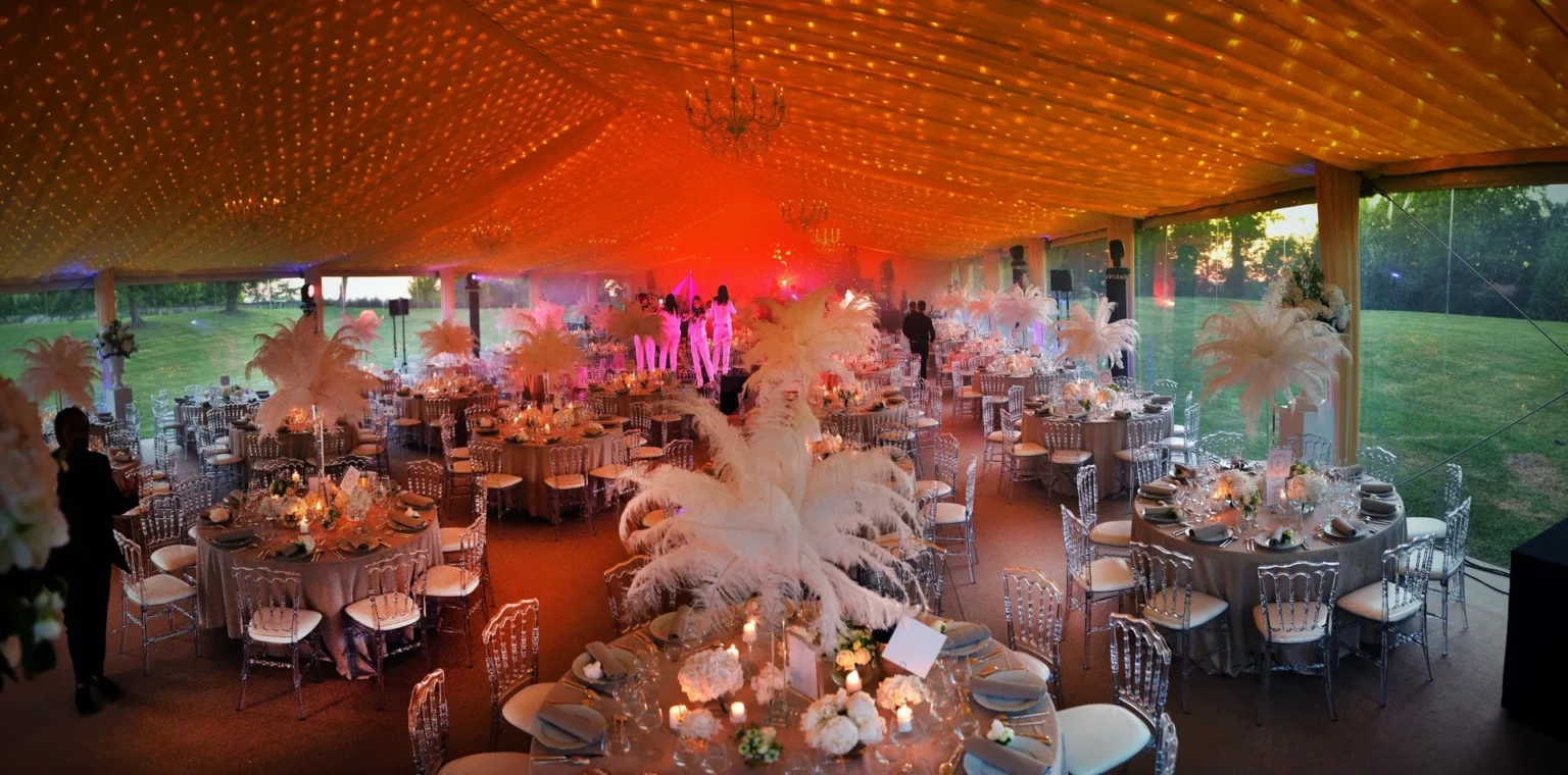 An evening gala dinner in a marquee at the château, with dressed tables and feather centrepieces