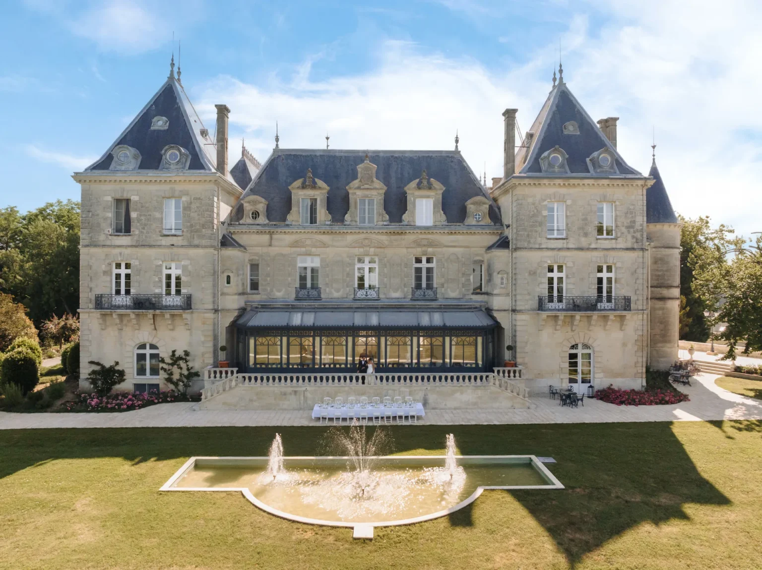 The garden façade of the château with the glass veranda above the lawn and fountain