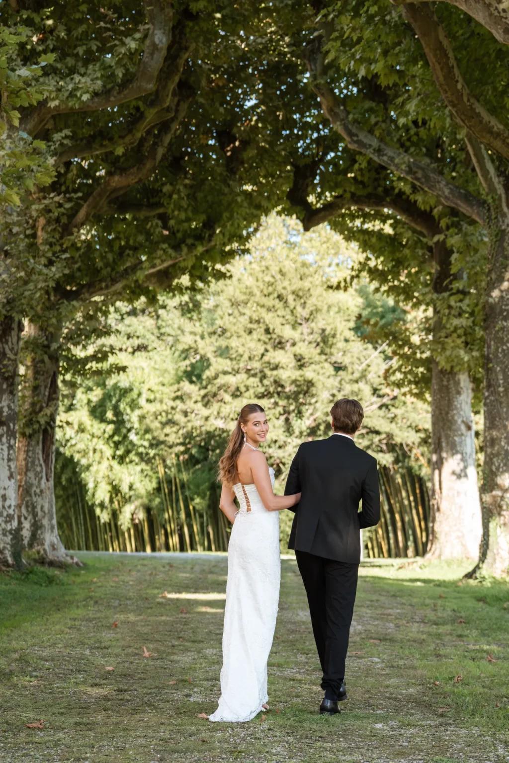 A bride and groom walking along the plane-tree allée